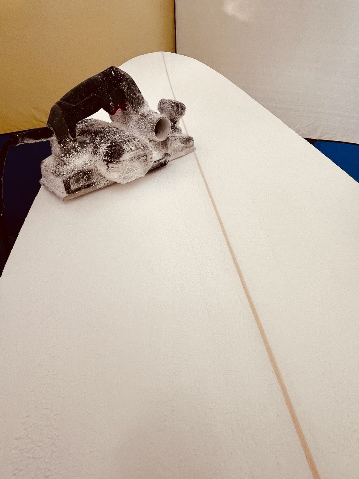 A hand planer resting on a freshly shaped blank