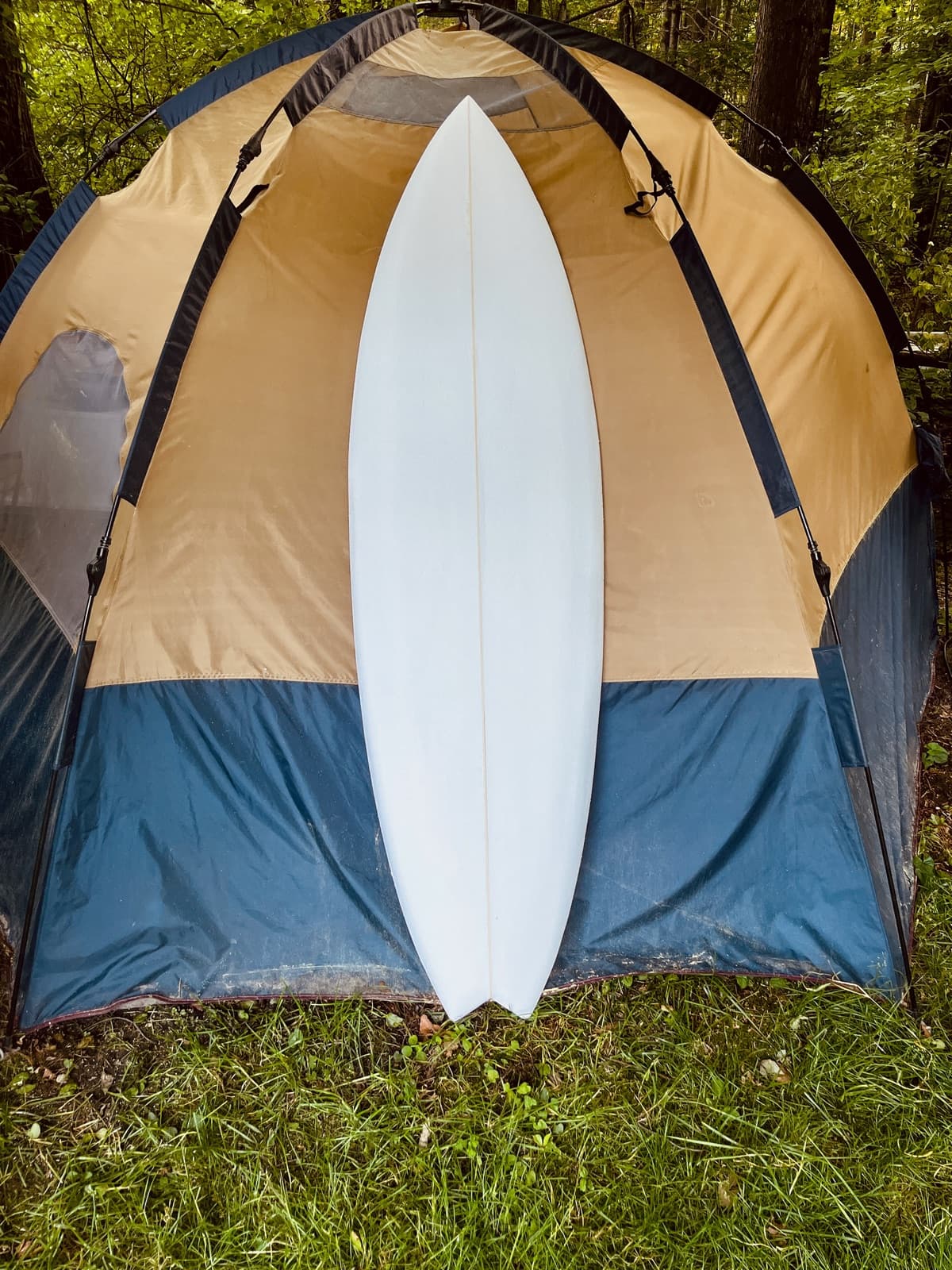 Hurley Hybrid shortboard propped against a camping tent