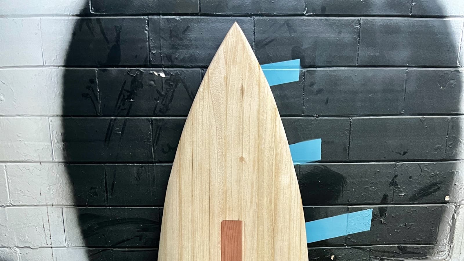 Wooden JJ blank against a black wall