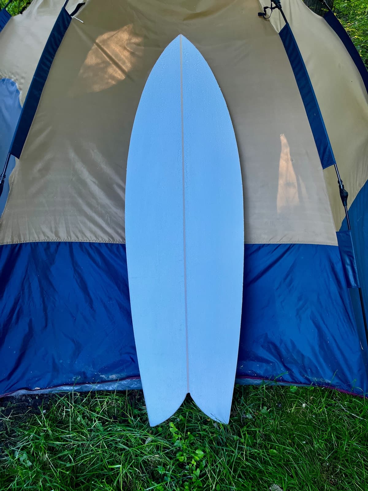 Sunfish twin keel fish propped against a camping tent