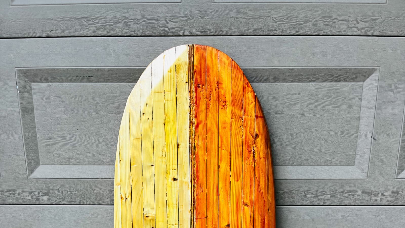 Nose of the wooden Vino against a garage door
