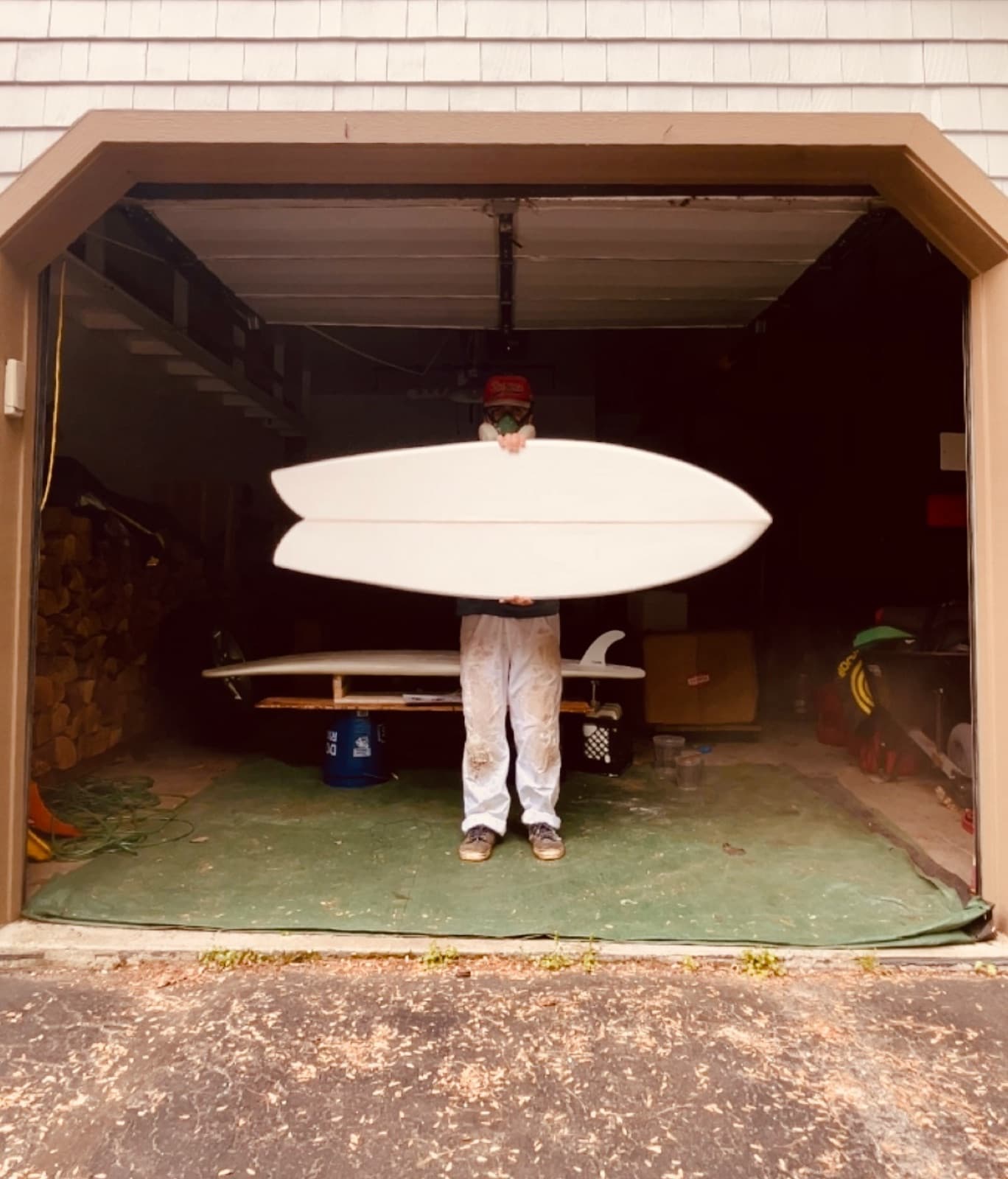 Two white surfboards held up in a garage doorway
